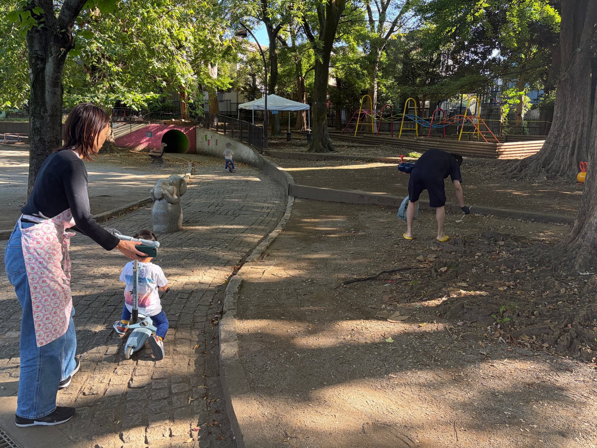 公園で大人と子どもたちが一緒にゴミ拾いをしている様子