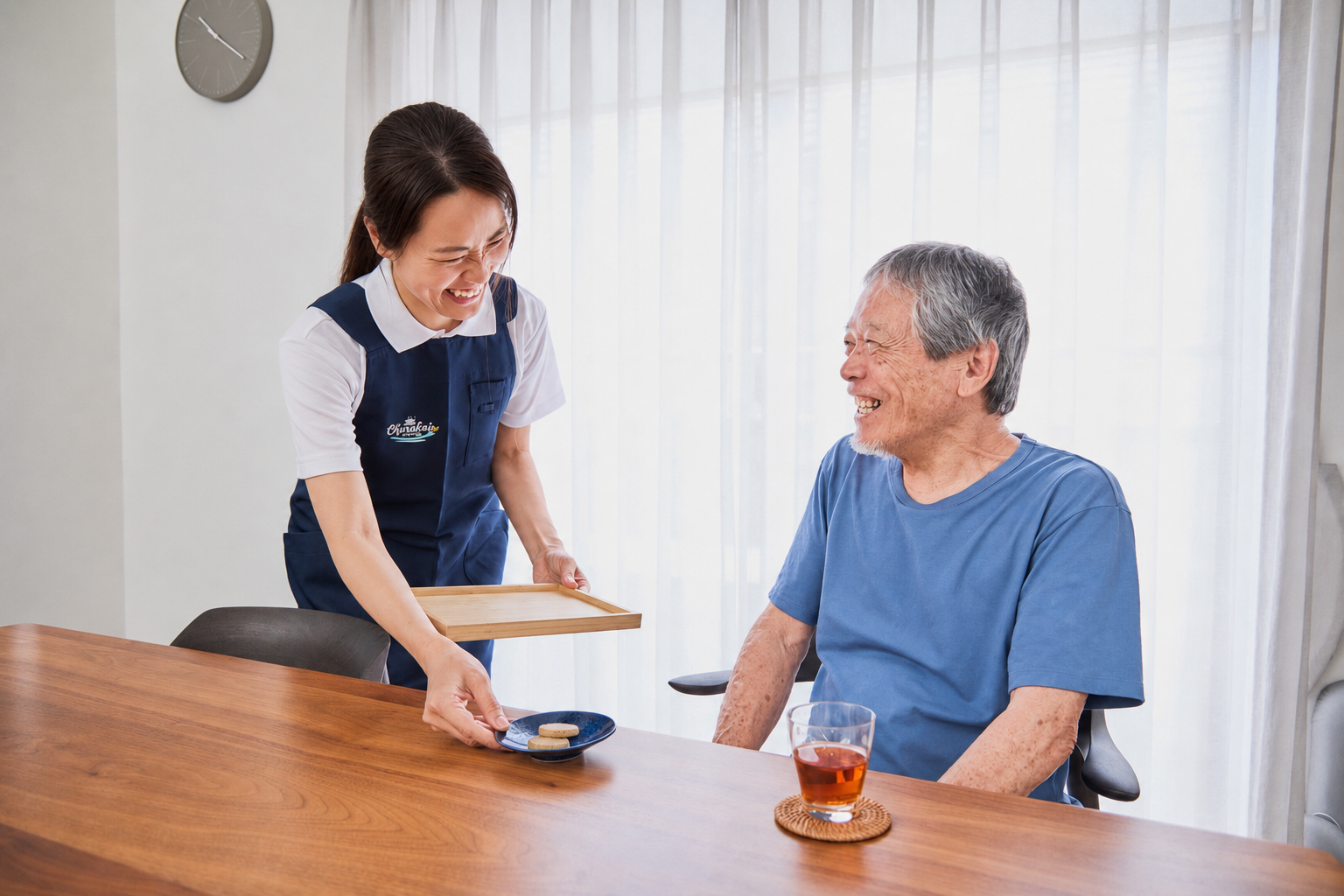 ちゅらカジのスタッフが、ご利用者さまにお茶をお出しして笑顔で会話している様子