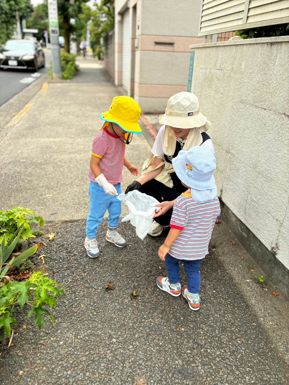 子どもたちとスタッフが一緒に歩道のゴミ拾いをしている様子